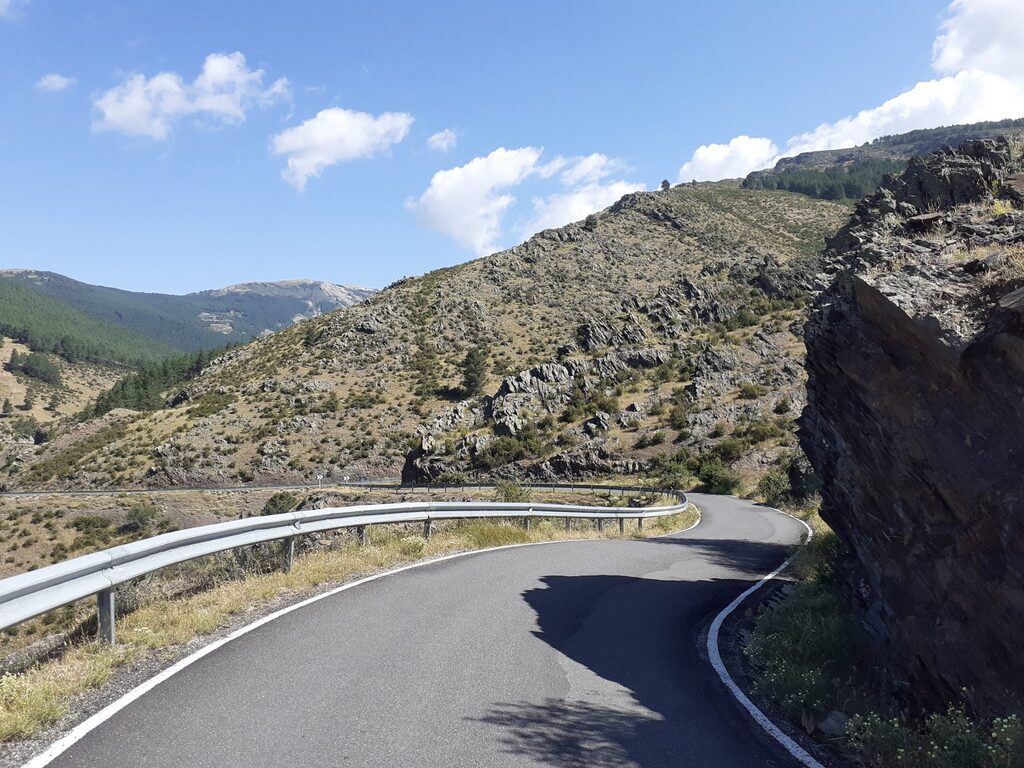 Carretera sinuosa en la montaña rodeada de un paisaje natural impresionante.