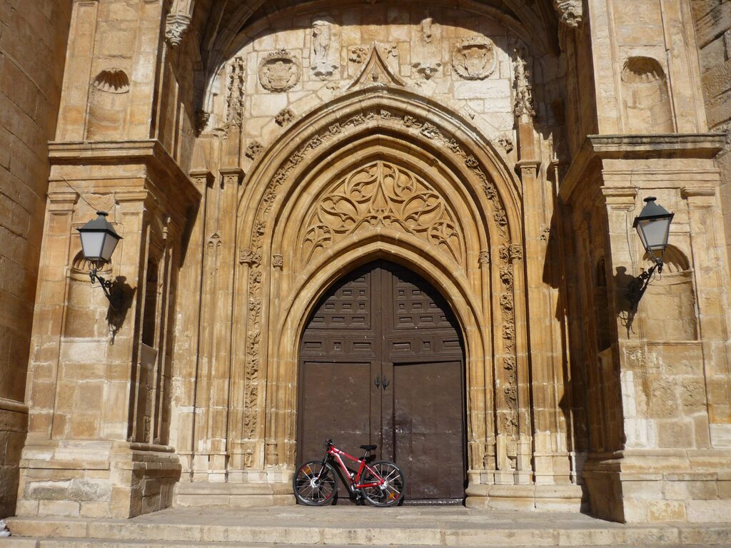 Vista de la iglesia de Torrelaguna con una bicicleta apoyada en su fachada.