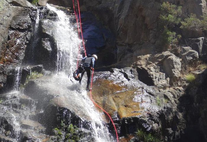 persona descendiendo una cascada en Somosierra
