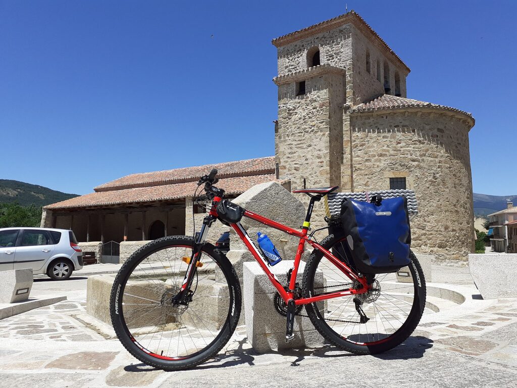 Vista de la iglesia de Prádena con una bicicleta