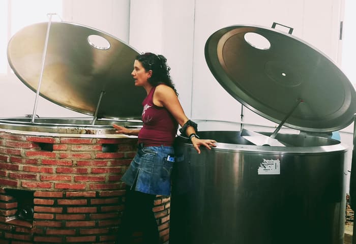 Mujer junto a tanques de fermentación en la fábrica de cerveza Bailandera.